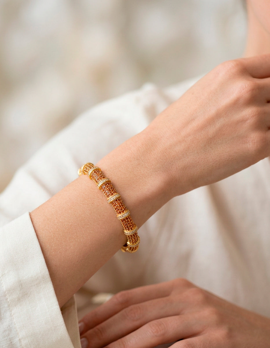 Brazalete de bronce con baño de oro 22k y espinolitas naranjas con separación de espinolitas blancas