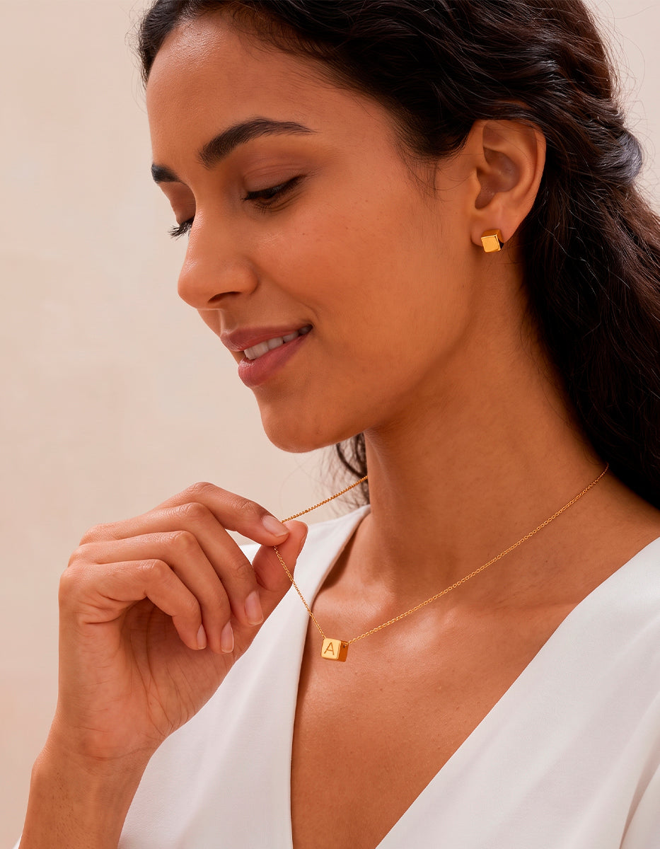 Set de collar con cubo grabado y aretes en bronce con baño de oro 22k