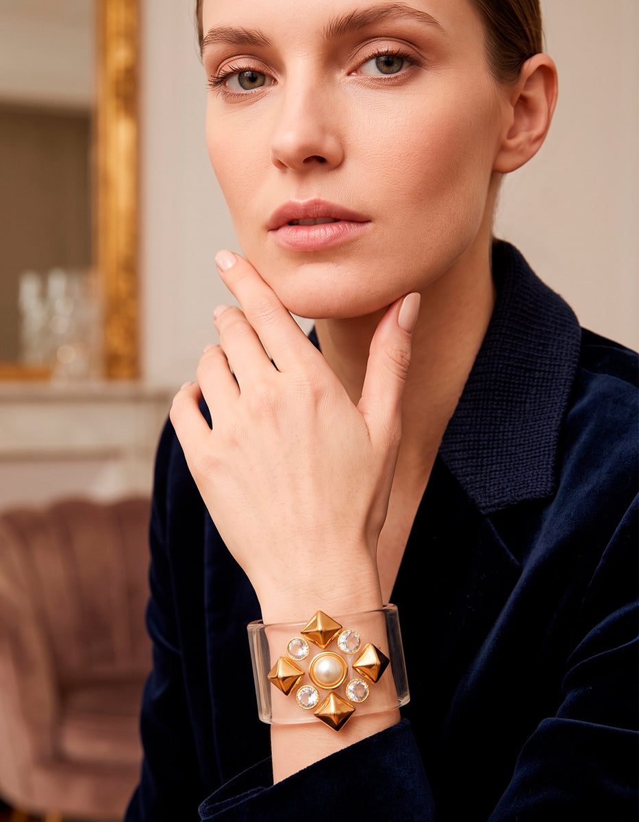 Brazalete Rígido en Acrílico Transparente con Medallón Dorado, Perla y Topacios Blancos Corte Brillante