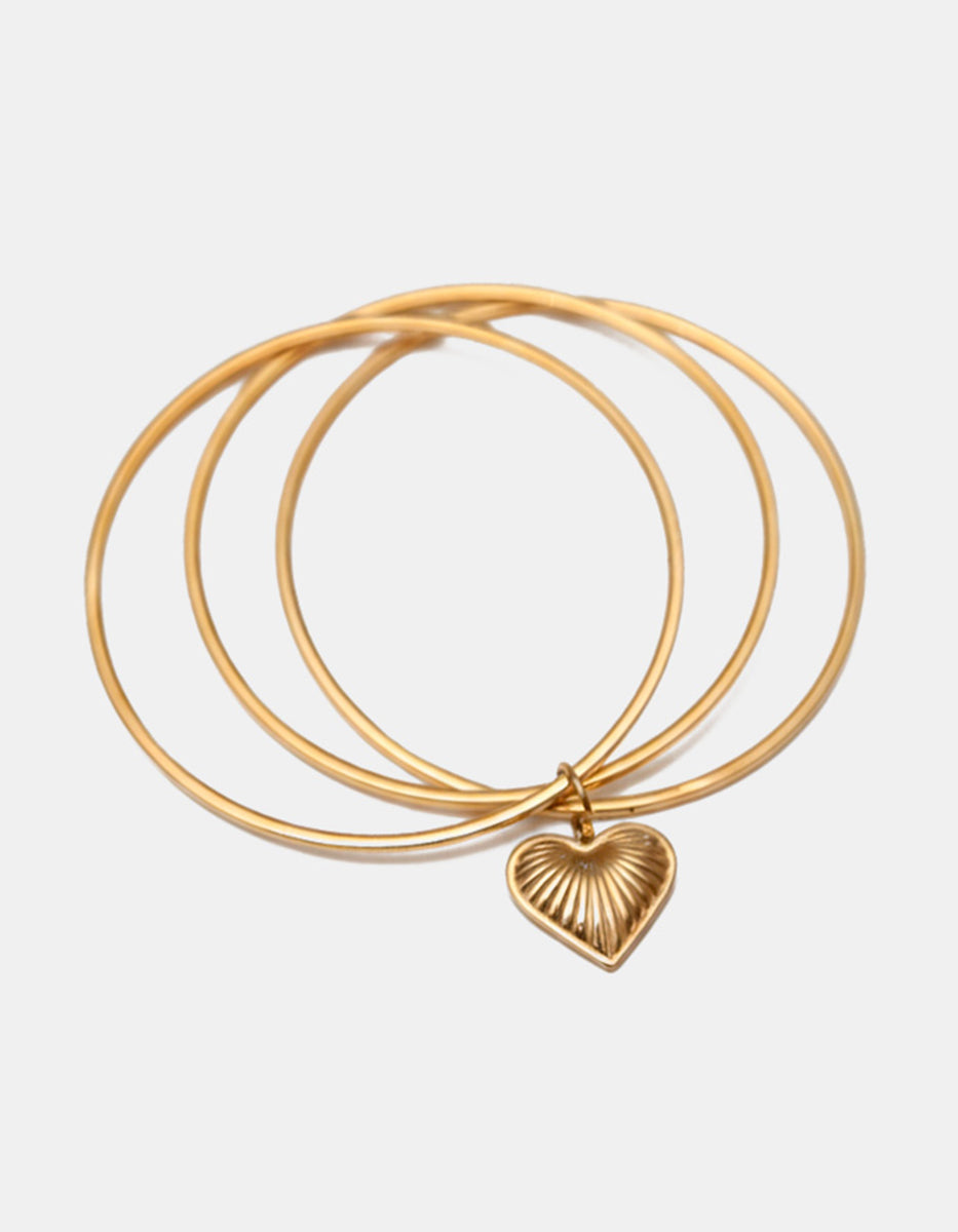 Brazalete en bronce con baño de oro 22 kt y charm de corazón texturizado Love Story