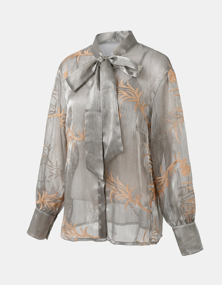Blusa Translúcida Gris Plateado con Bordados Florales Dorados y Lazo al Cuello