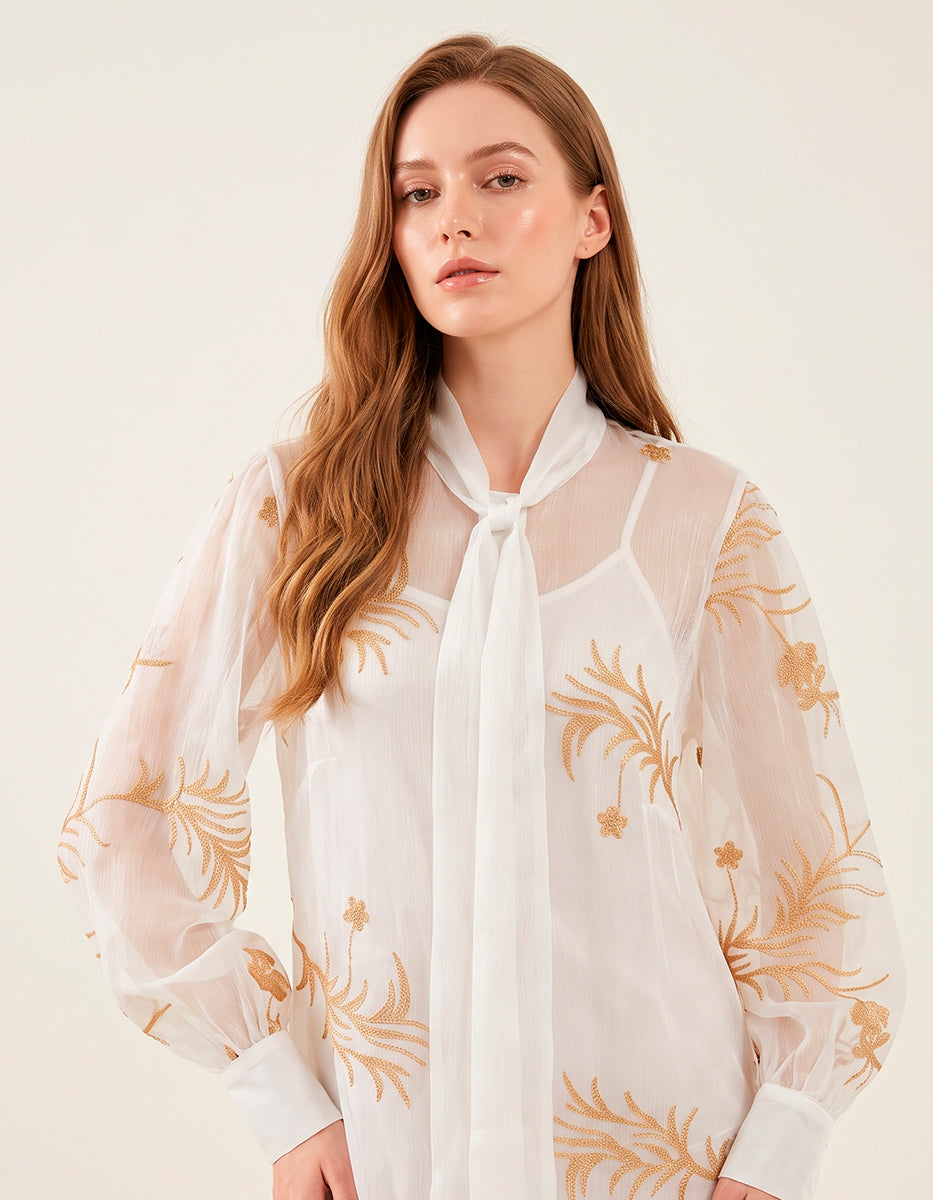 Blusa Translúcida Blanca con Bordados Florales Dorados y Lazo al Cuello