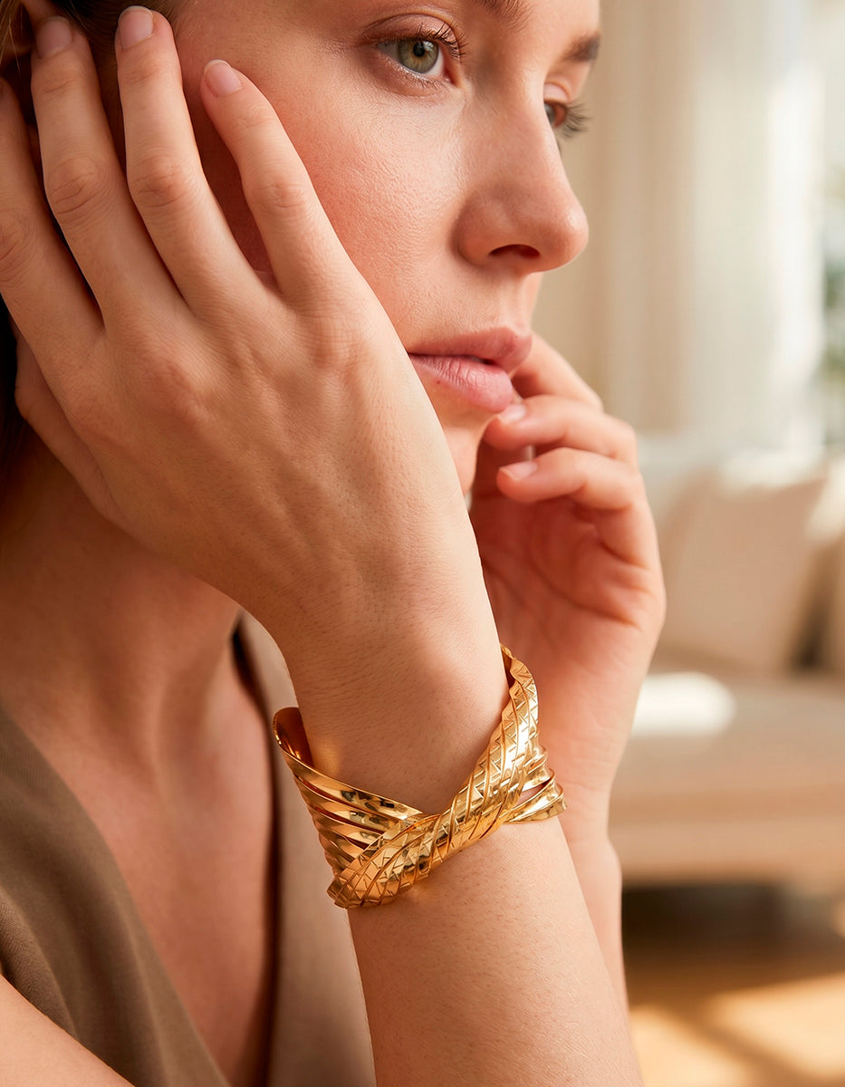 Brazalete de oro laminado 22kt en forma de nudo central con textura trenzada y bandas pulidas Golden Chic