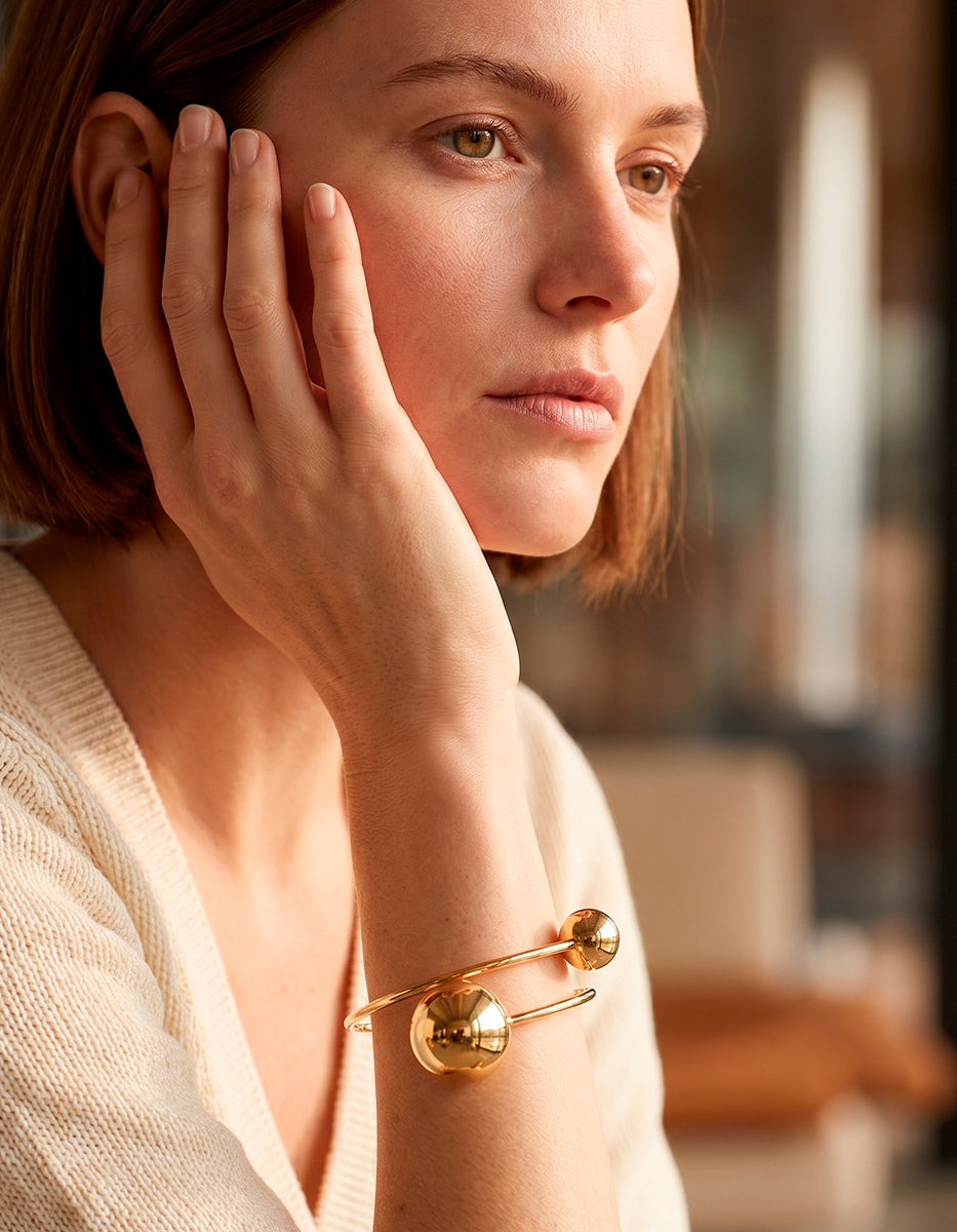 Brazalete de oro laminado 22k con diseño de doble esfera asimétrica y aro rígido Golden Chic
