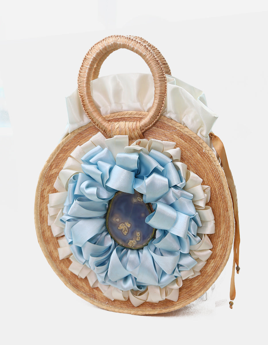 Bolso artesanal circular de palma con rosetón satinado azul y aplique de ágata natural Ultramar