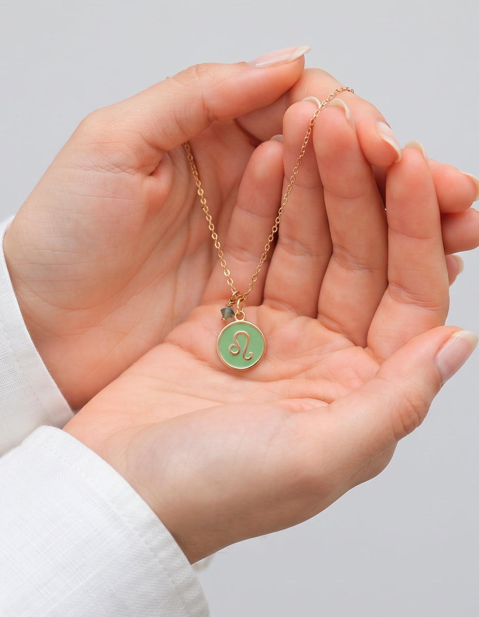 Collar Gold-Filled de 22kt con charm esmaltado de Leo y cristal austriaco verde Zodiac