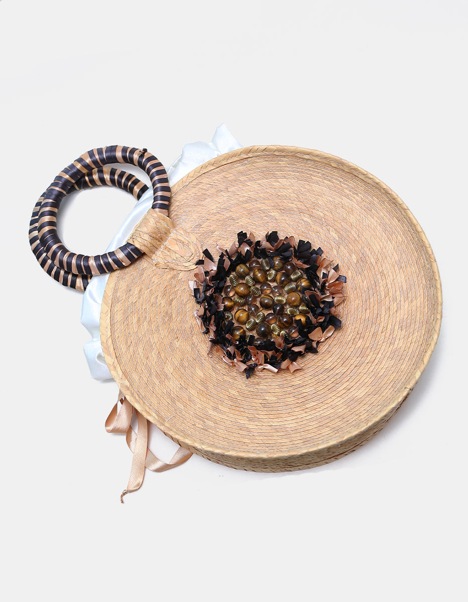 Bolso artesanal circular de palma tejida con medallón de ojo de tigre y asa a rayas Ultramar
