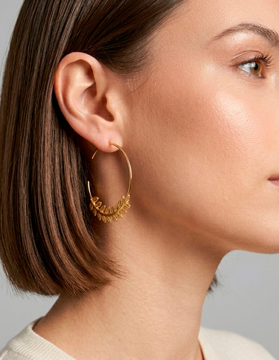Aretes de oro laminado 22k media arracada con diseño de hoja de laurel Golden Chic