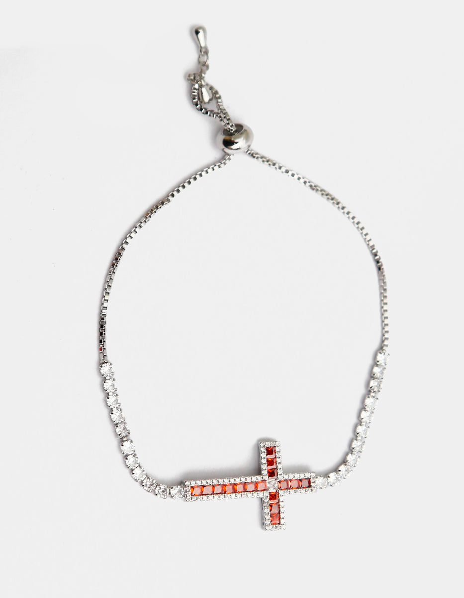 Pulsera en metales nobles con baño de platino y piedra granate roja en forma de cruz de 2.5 cm · Festive Style