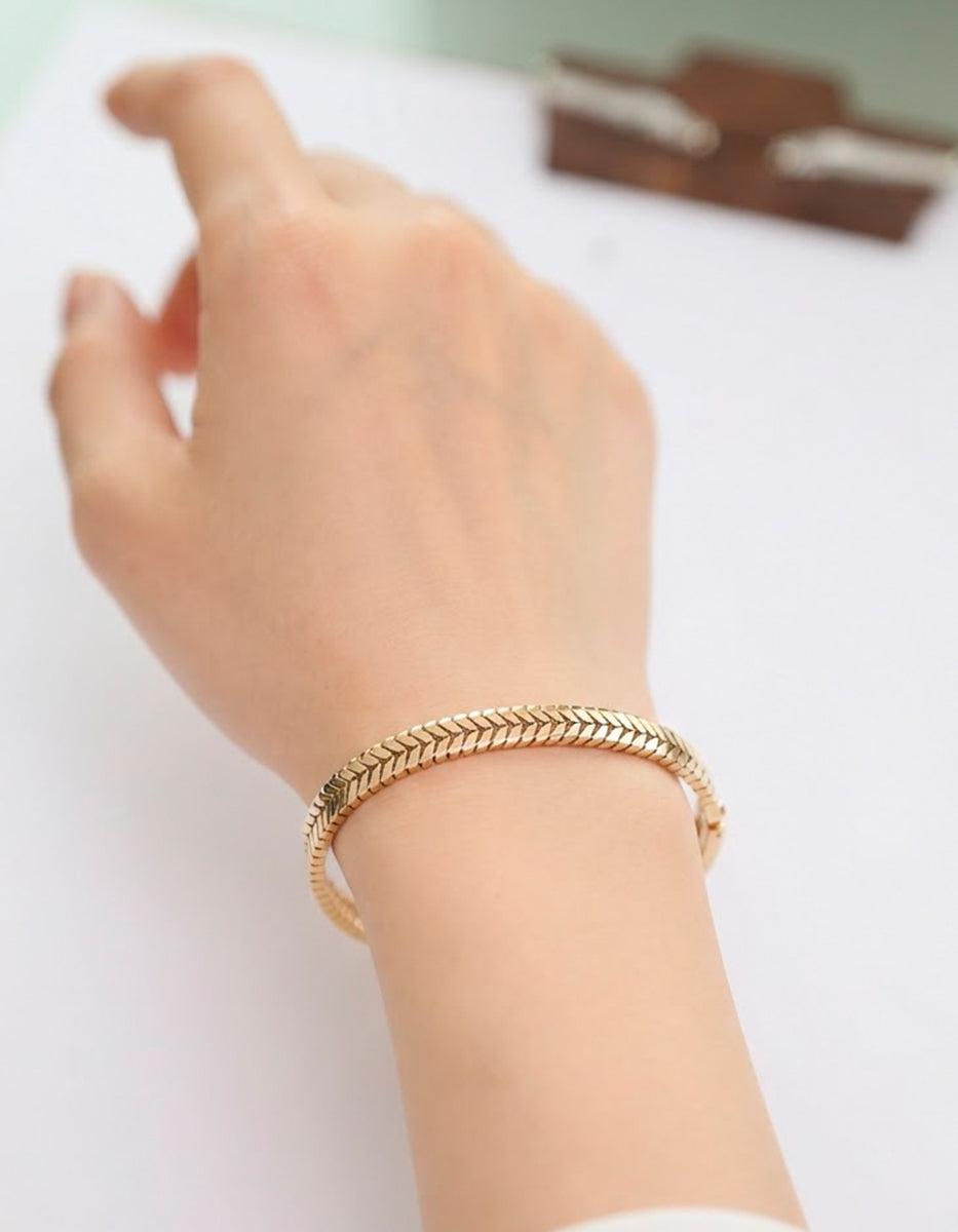 Brazalete rígido de bronce en baño de oro 22 kt con diseño texturizado en patrón de espiga