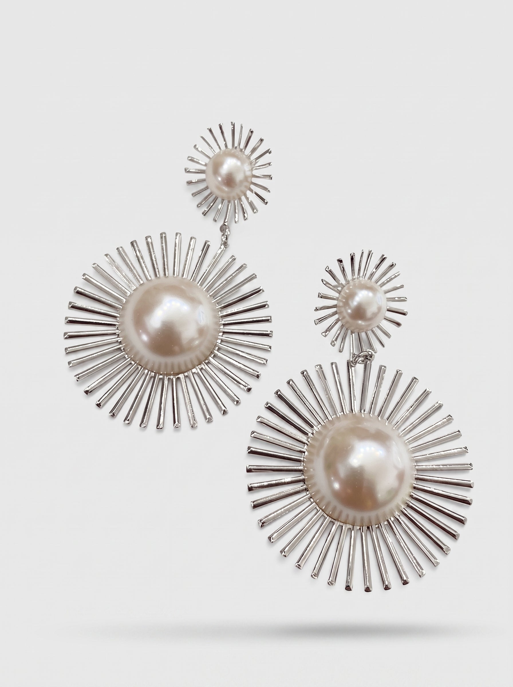 Aretes statement celestiales en baño platino con rosetón radiante y perla Mabe