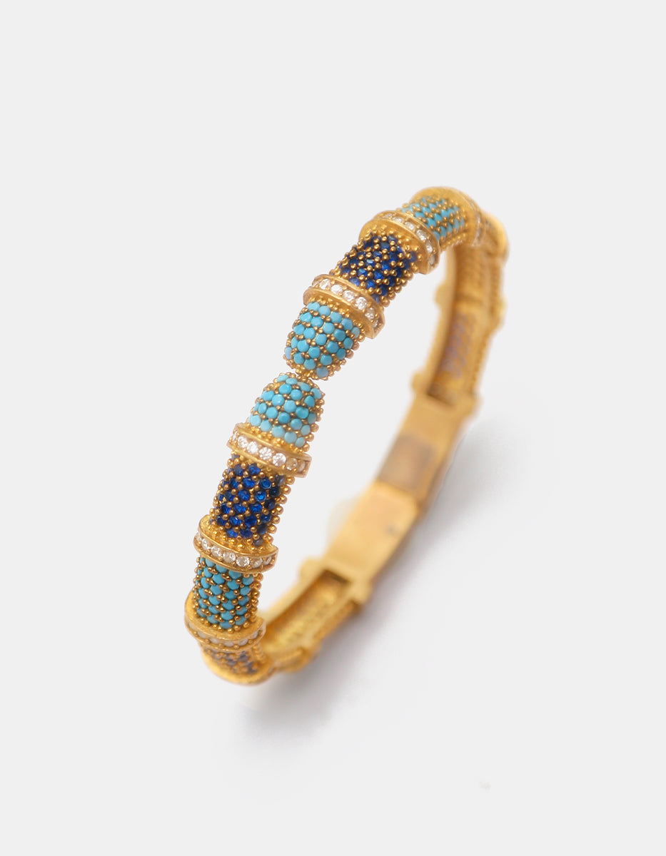 Brazalete rígido en baño de oro con espinolita tono turquesa, azul zafiro y topacios blancos