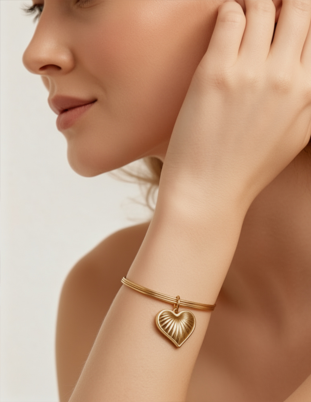 Brazalete en bronce con baño de oro 22 kt y charm de corazón texturizado Love Story