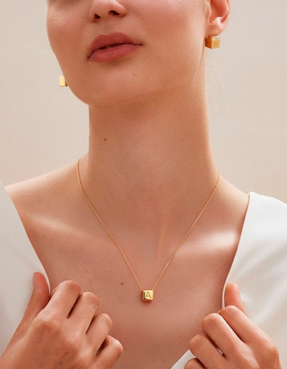 Set de collar con cubo grabado y aretes en bronce con baño de oro 22k