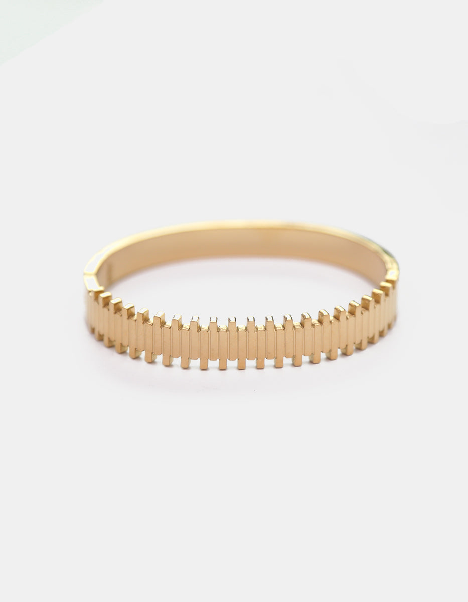 Brazalete rígido de bronce en baño de oro 22 kt con diseño geométrico texturizado