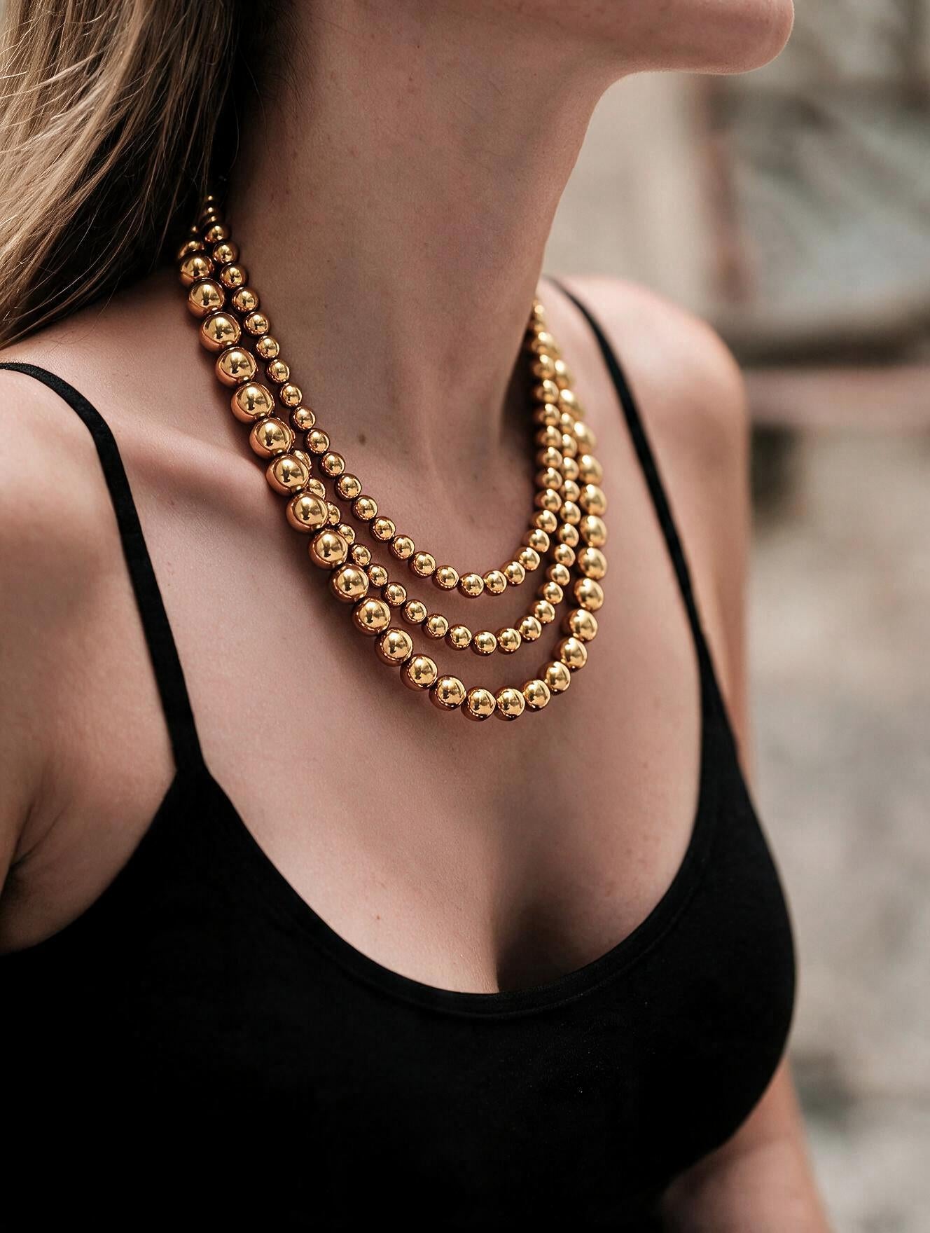 Collar de 3 hilos de bronce en baño de oro de 22kt con esferas en escala de tamaño Universe