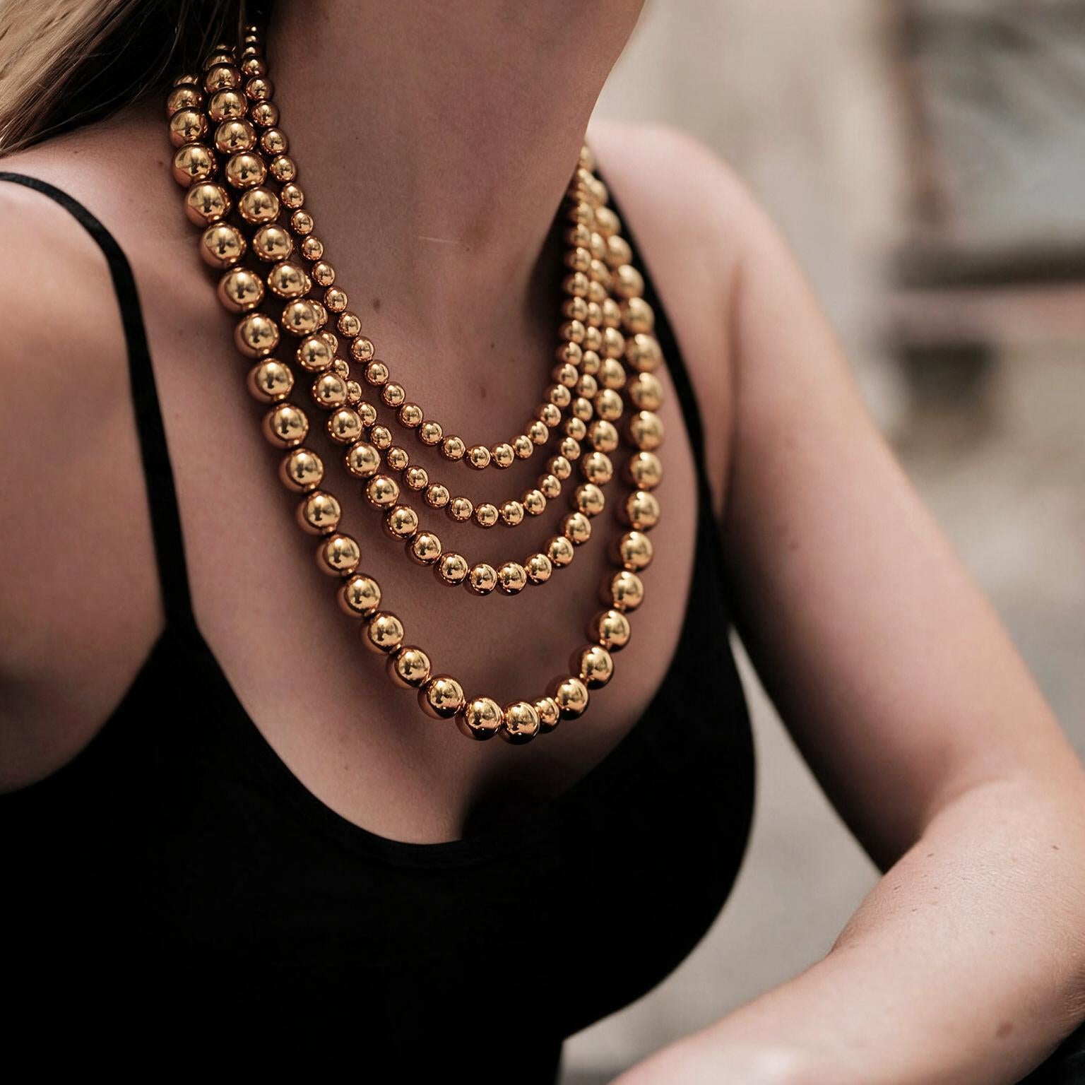 Collar de 4 hilos de bronce en baño de oro de 22kt con esferas en escala de tamaño Universe