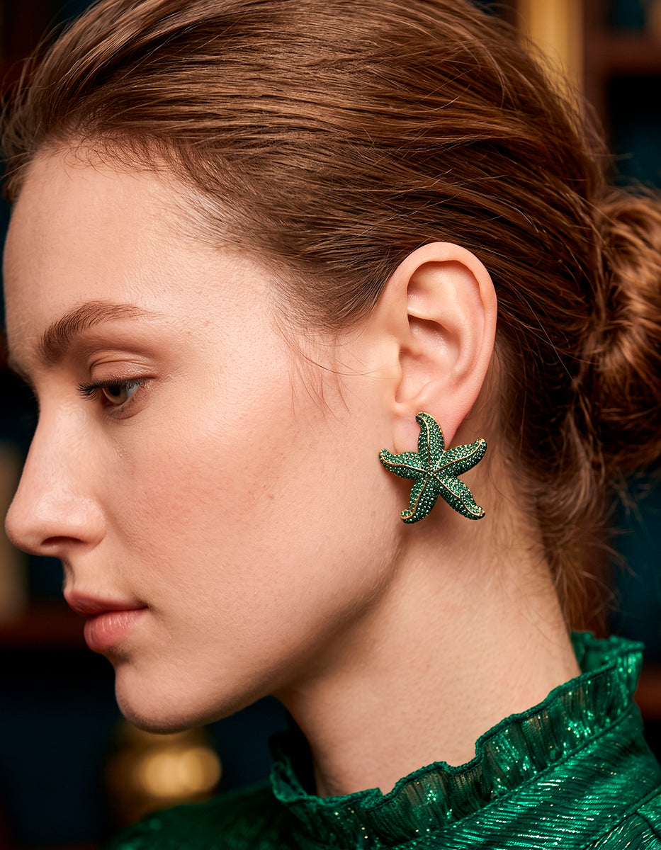 Aretes estrella de mar en bronce con baño de oro de 22kt y espinolitas verdes en corte brillante