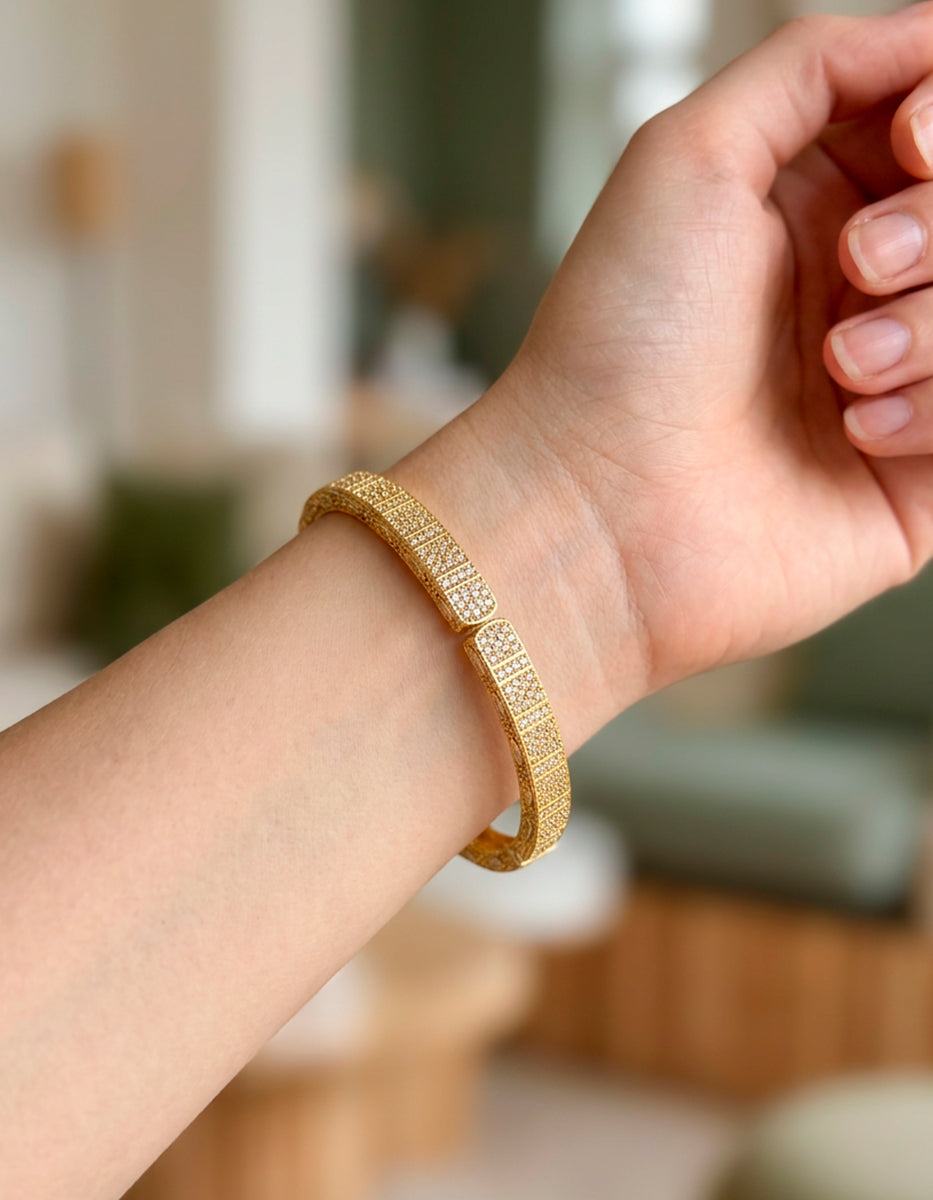 Brazalete de bronce con baño de oro 22k y espinolitas blancas con grecas Golden Chic