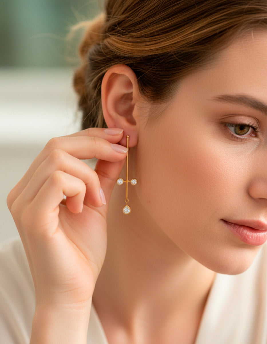 Aretes de oro laminado 22 kt con barra vertical y topacios blancos corte brillante y pera