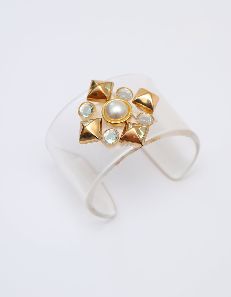 Brazalete Rígido en Acrílico Transparente con Medallón Dorado, Perla y Topacios Blancos Corte Brillante