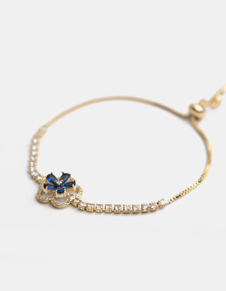 Pulsera ajustable de metal noble con flor central de gema azul y topacios blancos