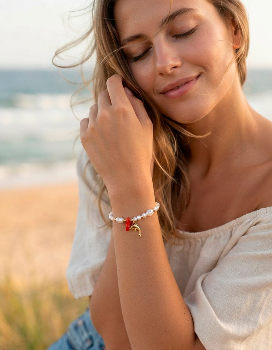 Pulsera de perlas con dije de delfín en Gold-Filled y detalle de baquelita roja Ultramar