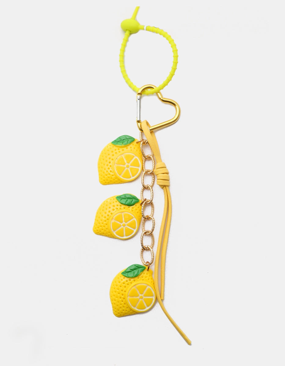 Charm para bolso con limones de acrilico, cordón de piel y corazón en oro laminado Ultramar