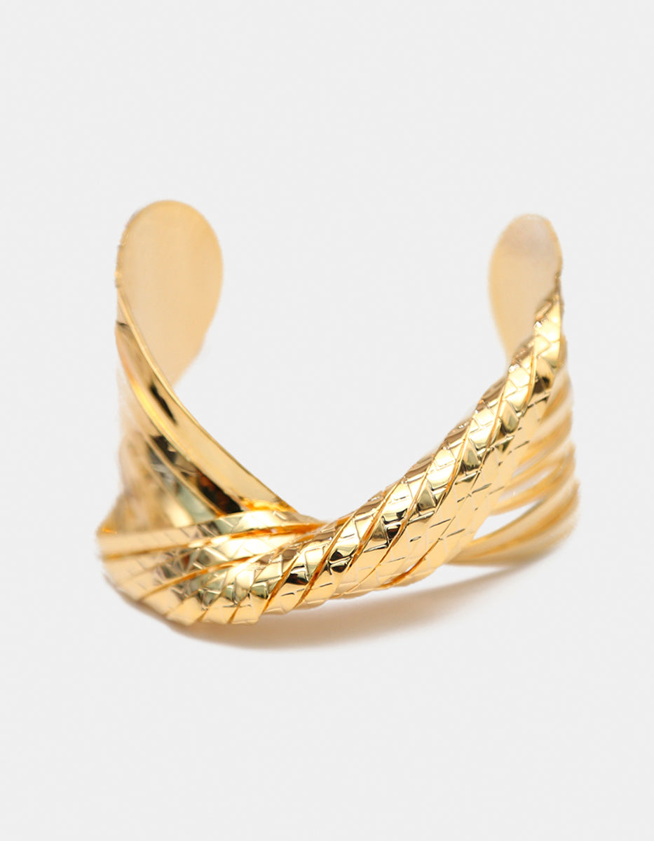Brazalete de oro laminado 22kt en forma de nudo central con textura trenzada y bandas pulidas Golden Chic