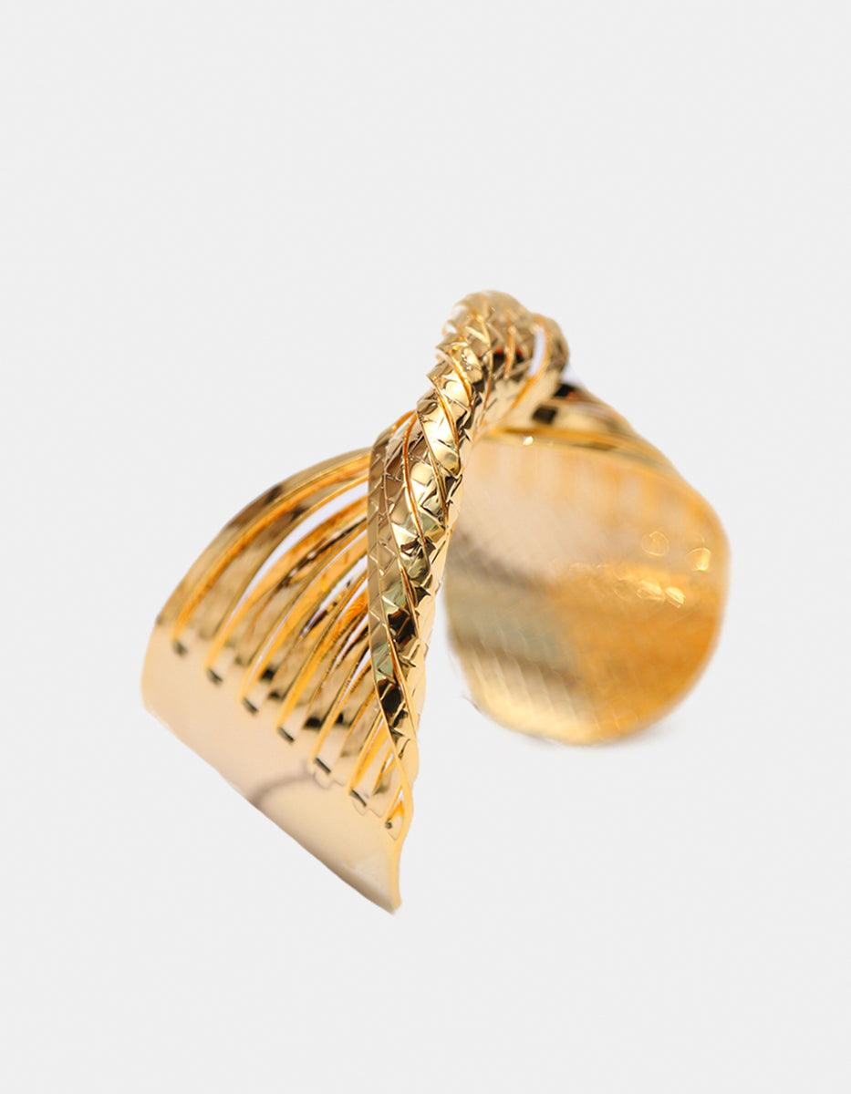 Brazalete de oro laminado 22kt en forma de nudo central con textura trenzada y bandas pulidas Golden Chic