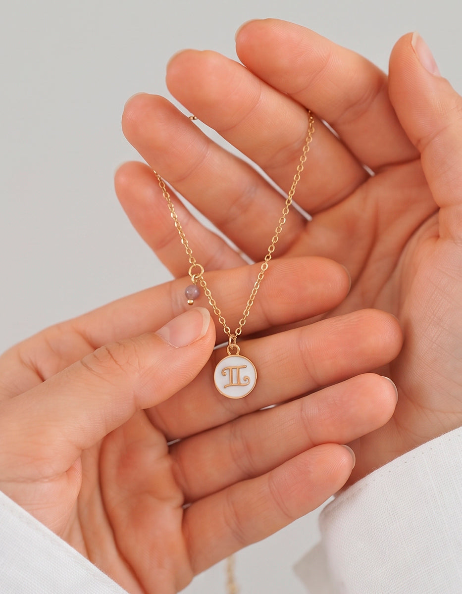 Collar Gold-Filled de 22kt con charm esmaltado de Géminis y cristal austriaco color durazno Zodiac