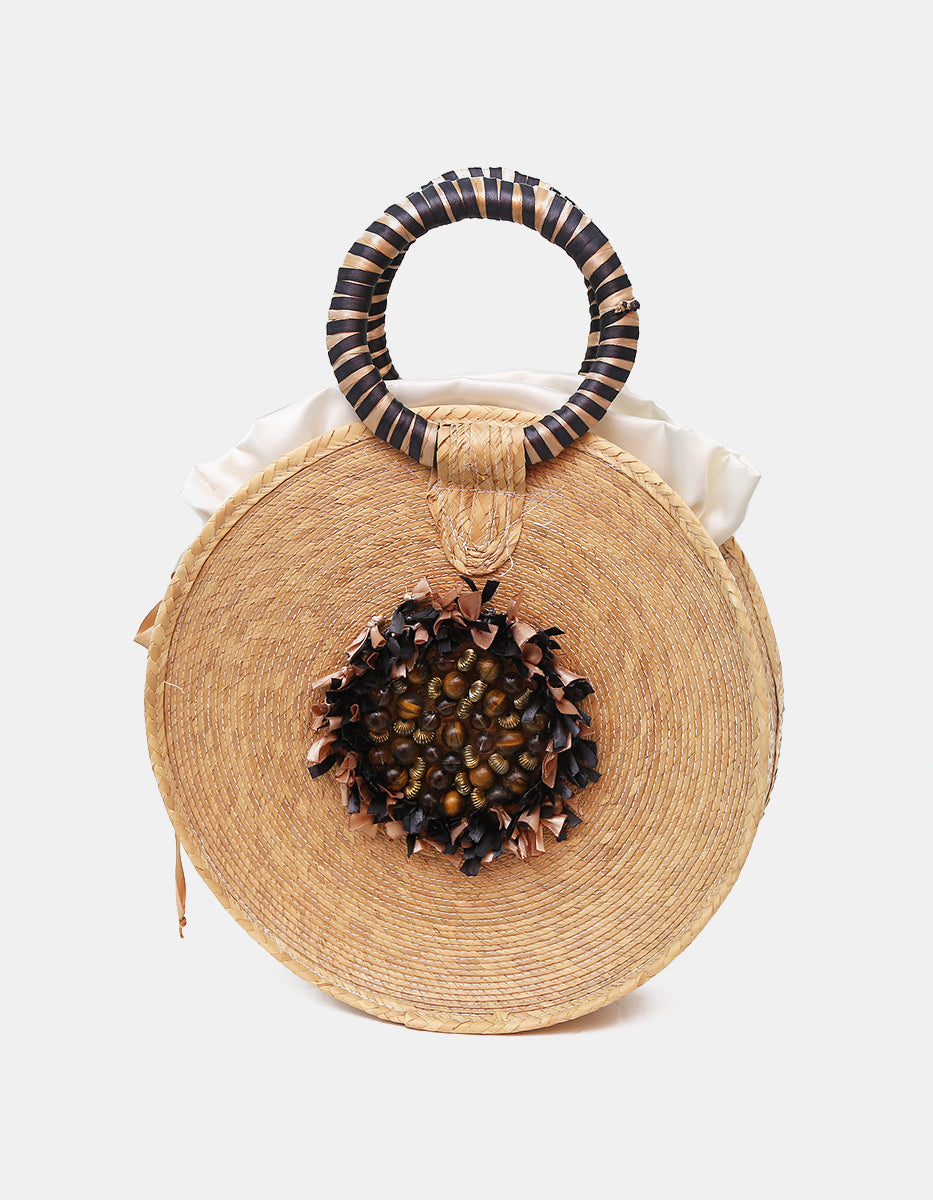 Bolso artesanal circular de palma tejida con medallón de ojo de tigre y asa a rayas Ultramar