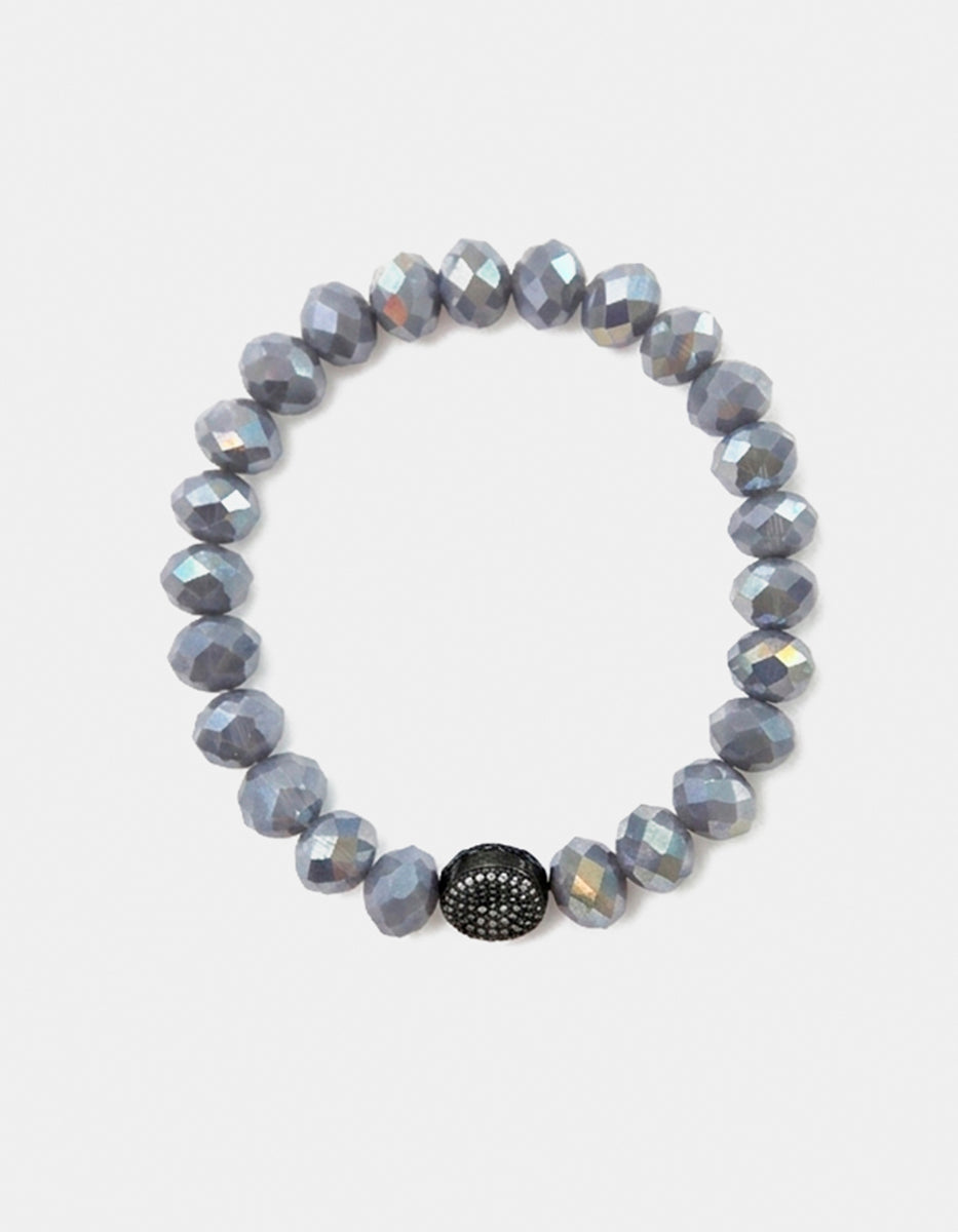 Pulsera de cristal gris metálico con dije esférico en bronce con baño de rutenio y circonias