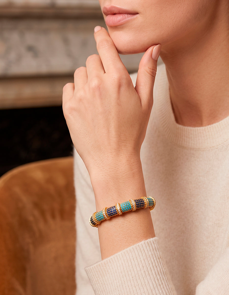 Brazalete rígido en baño de oro con espinolita tono turquesa, azul zafiro y topacios blancos