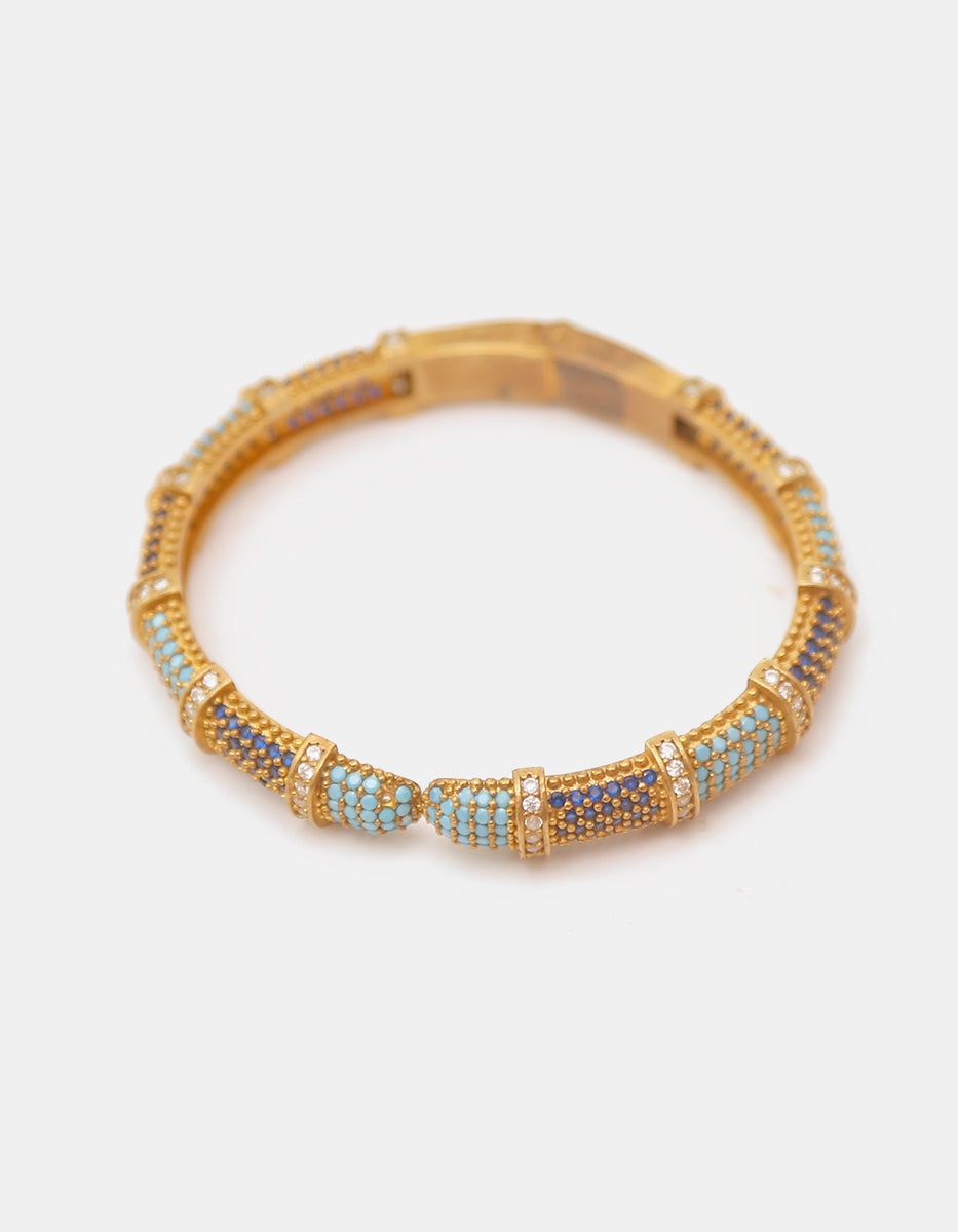 Brazalete rígido en baño de oro con espinolita tono turquesa, azul zafiro y topacios blancos