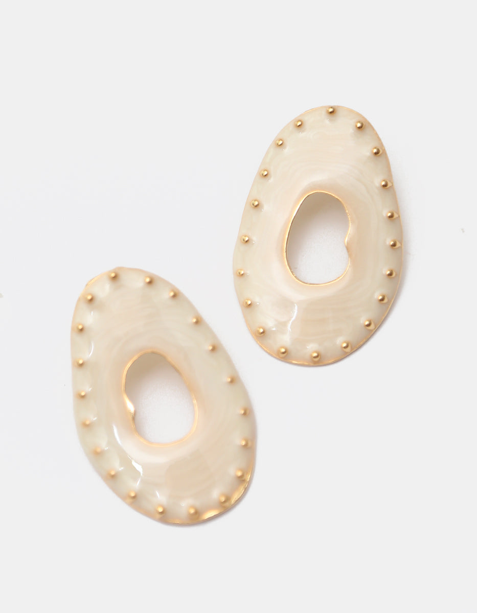 Aretes de silueta orgánica calada en esmalte marfil y detalles en baño de oro de 22kt