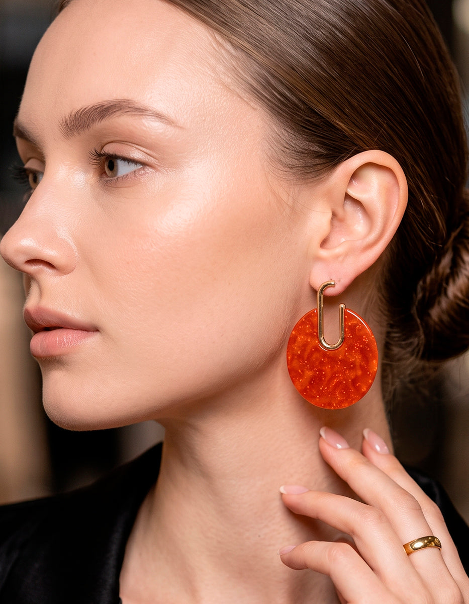Aretes en bronce con baño de oro de 22kt y disco circular en baquelita ámbar terracota